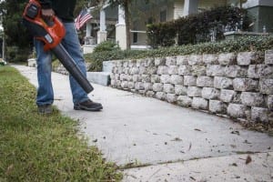 blowing leaves and grass off the sidewalk